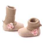 Jolie paire de bootes chaussette beige avec une petite rose sur l'extérieure de la botte. Pour bébé fille.