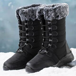 Photo d'une paire de bottes noires à lacets, imperméables noires et fourrées dans la neige.