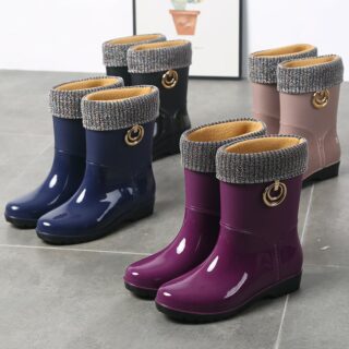 quatre paires de botte imperméables en caoutchouc de quatre couleurs différentes organisées en quinconce sur un carrelage gris , il y en a une bleue, violette, beige et noire