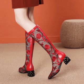 bottes rouges mi haute en dentelle avec motif de fleur à talon bas et carré, porté par une jeune femme dont on ne voit que les jambes et qui est en train de marcher